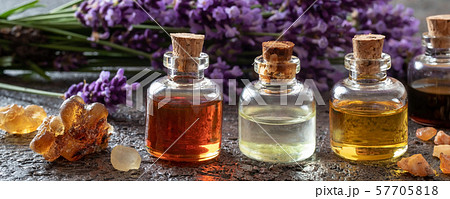 Panoramic header of essential oil bottles with frankincense, benzoin and lavender flowers Panoramic header of essential oil bottles with frankincense, benzoin and lavender flowers 57705818