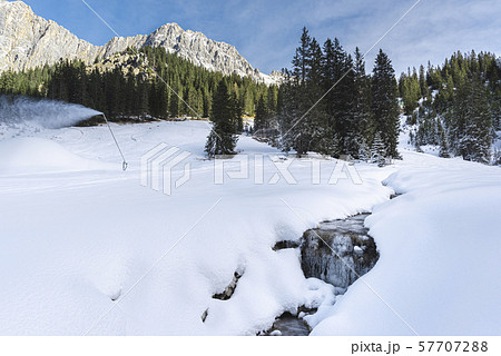 Snowdrifts near frozen creek in Austrian Alps. Snowdrifts near frozen creek in Austrian Alps. 57707288