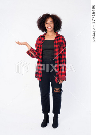Full body shot of happy young beautiful African hipster woman showing something Full body shot of happy young beautiful African hipster woman showing something 57716496