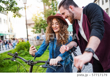 Young couple with electric scooters and smartphone in town, taking selfie. Young couple with electric scooters and smartphone in town, taking selfie. 57717179