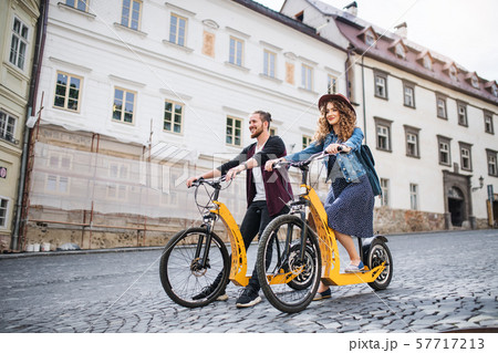 Young tourist couple travellers with electric scooters in small town. 57717213