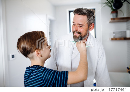 Mature father with small son in the bathroom in the morning, combing. 57717464