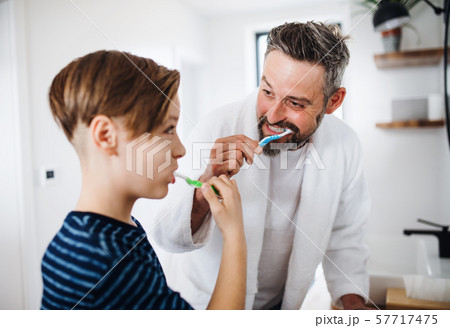 Mature father with small son in the bathroom in the morning, brushing teeth. 57717475