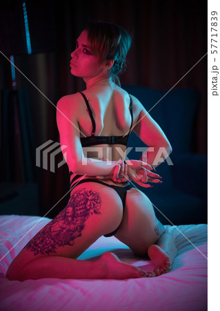 Young confident woman in a sexy underwear sitting on the bed on her knees and posing Young confident woman in a sexy underwear sitting on the bed on her knees and posing 57717839