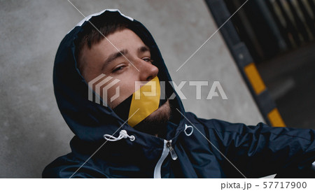 Man with tape over his mouth 57717900