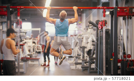 Men training in the gym - pulling up on the bar - drinking water Men training in the gym - pulling up on the bar - drinking water 57718021