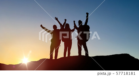 group of travellers with backpacks over sunrise 57718181