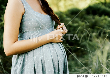 closeup pregnant belly in dress outside closeup pregnant belly in dress outside 57718316
