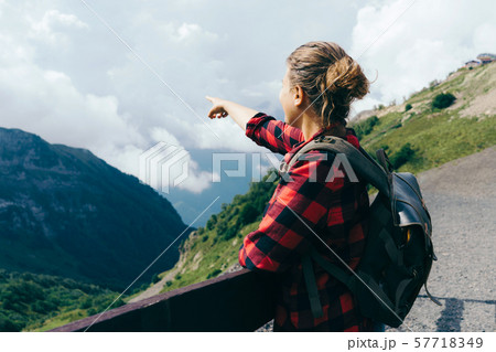 view from the back a woman points a finger in the mountains view from the back a woman points a finger in the mountains 57718349