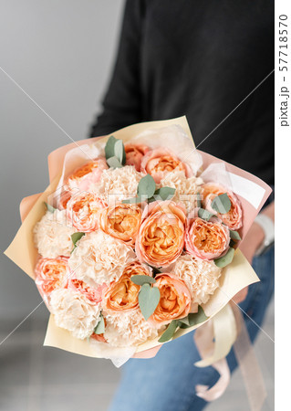White and peach color. Beautiful bouquet of mixed flowers in womans hands. the work of the florist White and peach color. Beautiful bouquet of mixed flowers in womans hands. the work of the florist 57718570