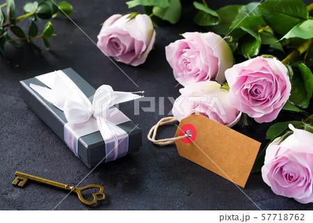 Pink roses and a gift box on a stone background. Vintage style, retro interior with flowers. Space 57718762