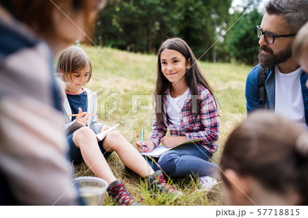 Group of school children with teacher on field trip in nature, learning science. 57718815