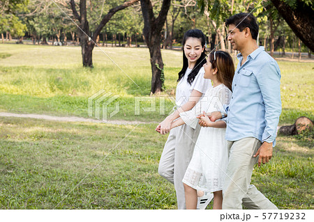 Parents and children walking hand in hand in the 57719232