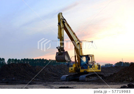 Excavator at a construction site on a background sunset.  57719983