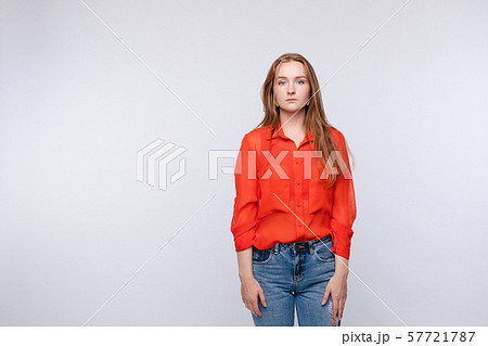Upset young woman wearing red blouse and jeans 57721787