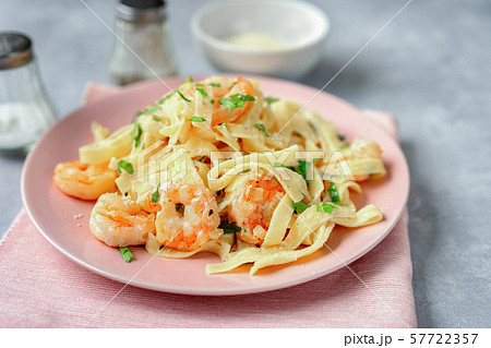 Close up of shrimp fettuccine alfredo in a pink plate Close up of shrimp fettuccine alfredo in a pink plate 57722357