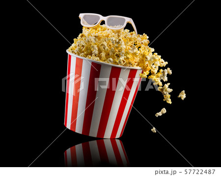 Flying popcorn from striped bucket isolated on black background 57722487