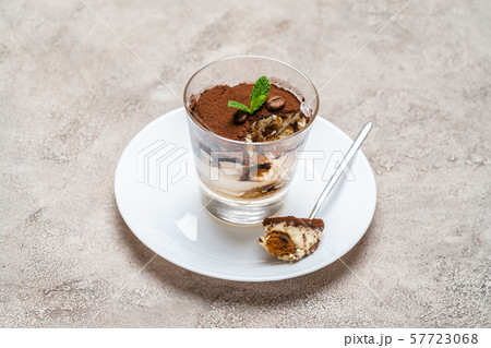 Portion of Classic tiramisu dessert in a glass cup on concrete background 57723068