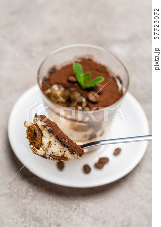 Portion of Classic tiramisu dessert in a glass cup on concrete background 57723072