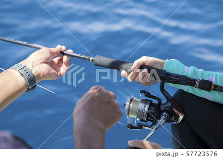 海釣りを子供の教えるお父さん手元 57723576