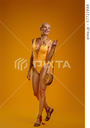 cute blonde girl in orange swimsuit posing 57727888