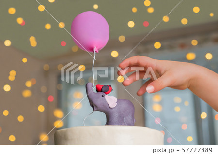 Delicious cake for one year old birthday. Cake for family holidays. Childs hand and cake decorated 57727889