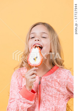 Little girl licks candy on stick Little girl licks candy on stick 57727944