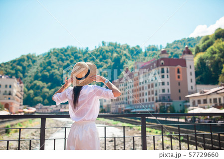 Happy girl at hat on the embankment of a mountain river in a European city. 57729660