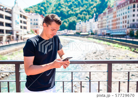 Man on the embankment of a mountain river in a European city. 57729670