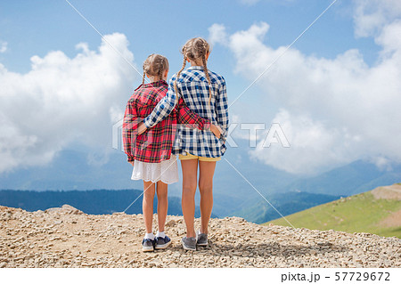 Beautiful happy little girls in mountains in the background of fog 57729672