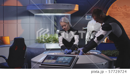 Biologists and robot planting seedlings on a Mars base Biologists and robot planting seedlings on a Mars base 57729724