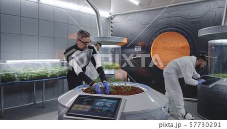 Scientist planting seedlings on Martian base Scientist planting seedlings on Martian base 57730291