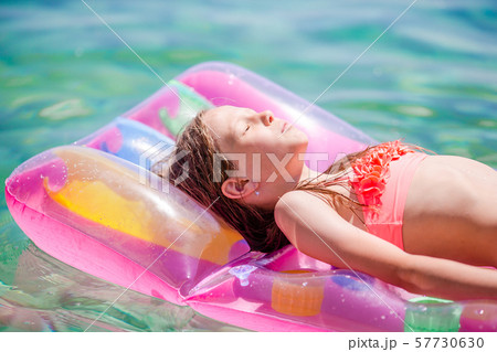 Adorable girl on inflatable air mattress in the sea 57730630