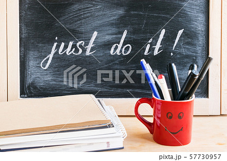 Lettering of phrase JUST DO IT on black chalkboard 57730957