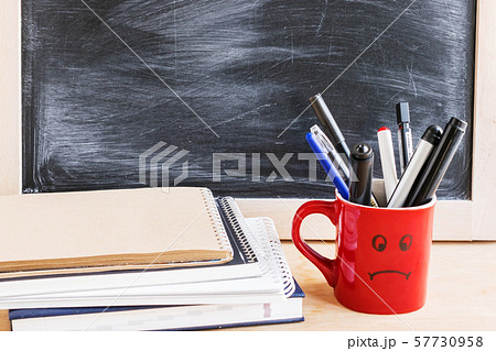 Black chalkboard background, notepads, diary and a 57730958