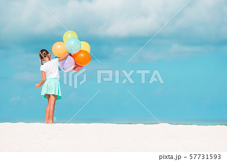 Adorable little girl playing with balloons at the beach 57731593