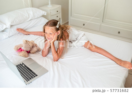 Cute little girl doing homework on laptop Cute little girl doing homework on laptop 57731682
