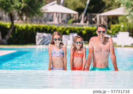 Happy family of four in outdoors swimming pool 57731716