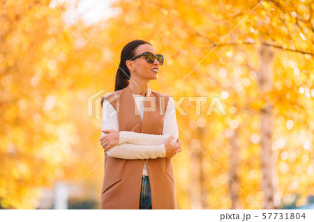 Fall concept - beautiful woman drinking coffee in autumn park under fall foliage Fall concept - beautiful woman drinking coffee in autumn park under fall foliage 57731804