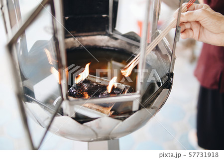 Hands of old men, light the incense sticks  57731918