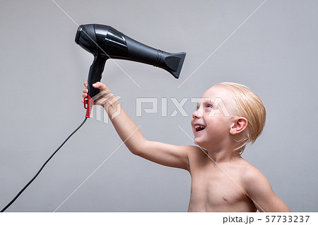 Blond boy with wet hair is funny dried by a 57733237