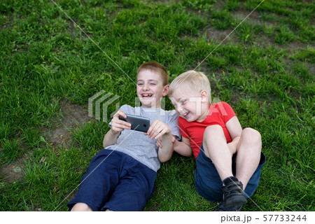 Two boys with a smartphone in their hands having Two boys with a smartphone in their hands having 57733244