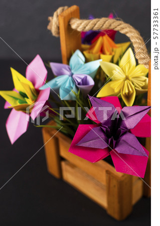 Handmade colored paper flowers origami bouquet paper craft art in a basket with grass in the studio 57733361