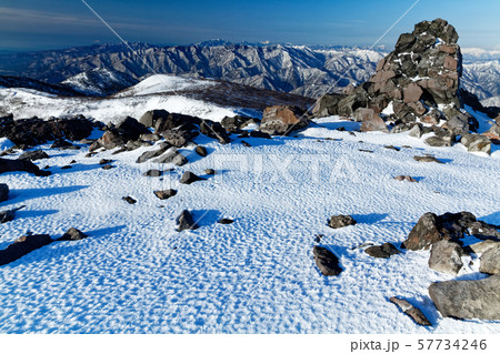 厳冬の那須・茶臼岳山頂の岩峰と奥日光の山並み 57734246