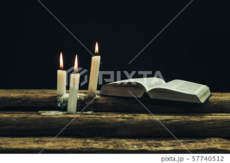 Beautiful open bible and burned candles on a old 57740512