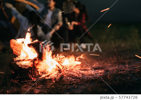 Sparking bonfire with tourist people sit around 57743726