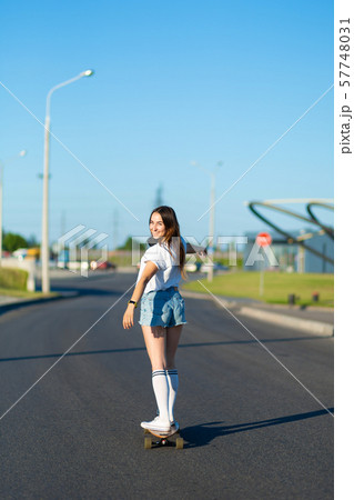 stylish girl in white stockings ride on longboard 57748031