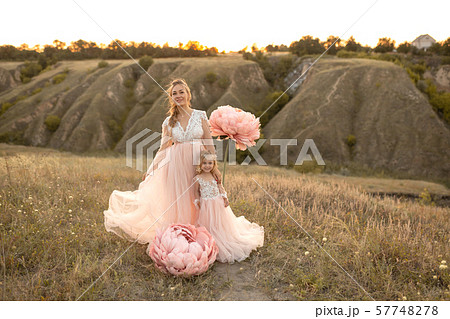 Mom with daughter in pink fairy-tale dresses walk Mom with daughter in pink fairy-tale dresses walk 57748278