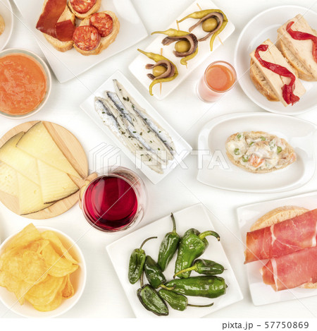 Spanish tapas, overhead square shot. Wine, sardines, Russian salad, padron peppers, jamon and other Spanish tapas, overhead square shot. Wine, sardines, Russian salad, padron peppers, jamon and other 57750869