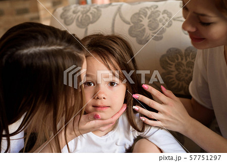 Pretty young mother and her sister reading a book to her daughter. 57751297